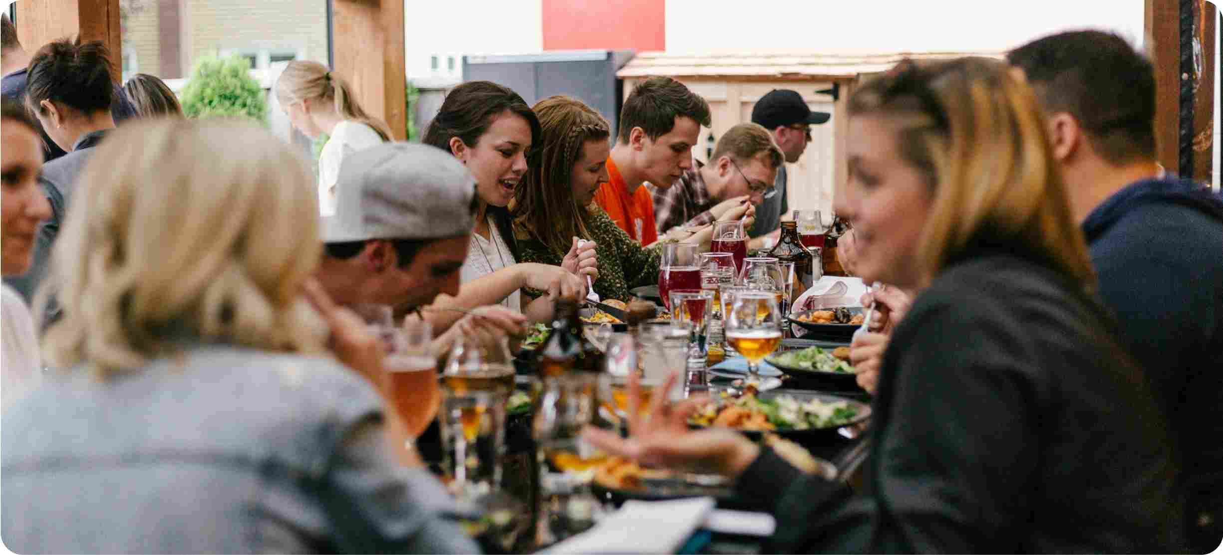 Group of people dining together at a table with food and drinks